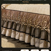 A set of three sheer beige bed skirts with ornate gold embroidery and black trim displayed on a bed.