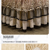 A tiered beige and gray fabric bed skirt set with decorative lace trim