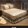A luxurious bed set featuring a beige quilted duvet and a tiered gold and gray bed skirt with decorative tassels.