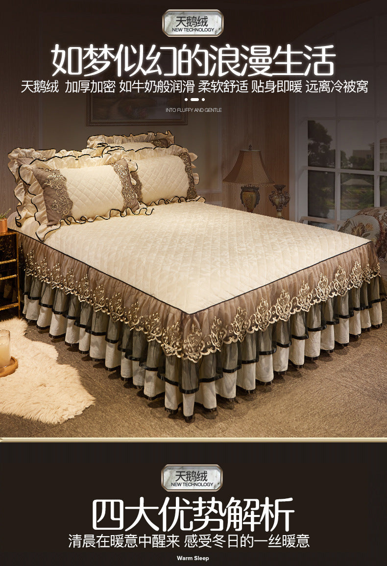 A luxurious bed set featuring a beige quilted duvet and a tiered gold and gray bed skirt with decorative tassels.