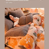 A close-up of a plush fleece blanket featuring individual fabric designs in shades of orange, beige, and brown.