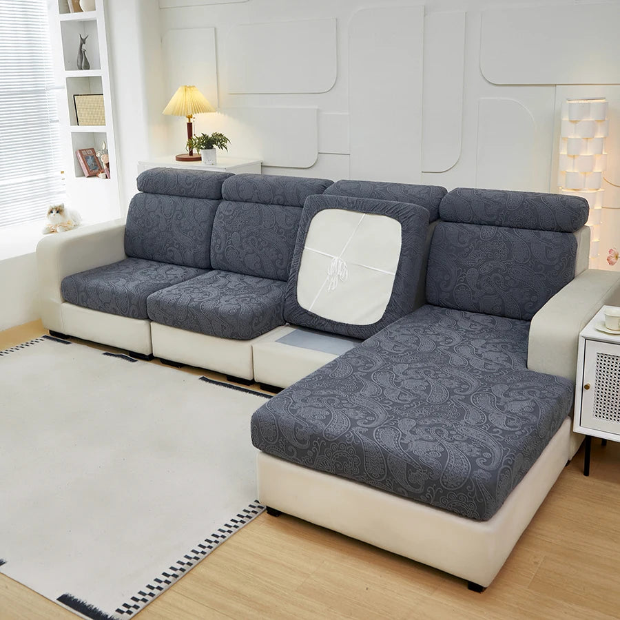 A gray and white sectional sofa with patterned cushion covers in a modern living room setting.