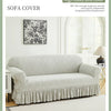 A light gray jacquard sofa cover is displayed on a sofa, showing its texture and drape.