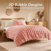 A pink plush faux fur bubble blanket is displayed on a bed, adding texture to the room.