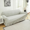 A light gray multifunctional sofa cover draped over a sofa in a bright room.