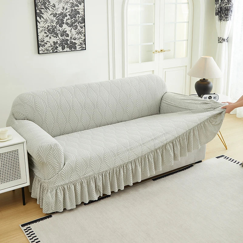 A light gray multifunctional sofa cover draped over a sofa in a bright room.