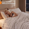 A woman is relaxing under a fluffy white faux fur blanket on a bed, emphasizing cozy warmth without overheating.
