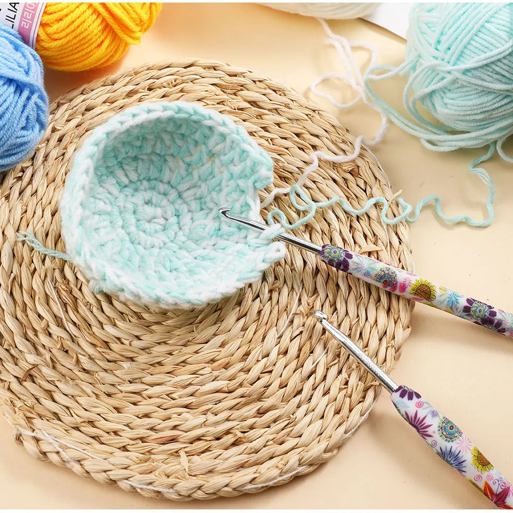 Handmade crochet knitting hooks and a light blue crocheted bowl resting on a woven mat.