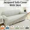 A light gray jacquard sofa cover with a skirt shown on a modern sofa.