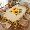 A long table covered with a sunflower floral waterproof tablecloth surrounded by wooden chairs.