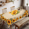 A long table covered with a yellow sunflower floral waterproof tablecloth set on a wooden dining table.