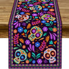 A vibrant purple and orange Day of the Dead sugar skull linen table runner featuring colorful floral patterns.
