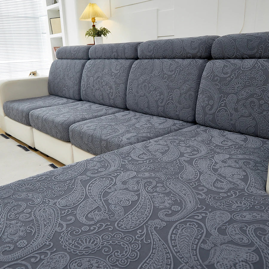 Gray patterned sofa cushion covers on a sectional sofa in a bright room.