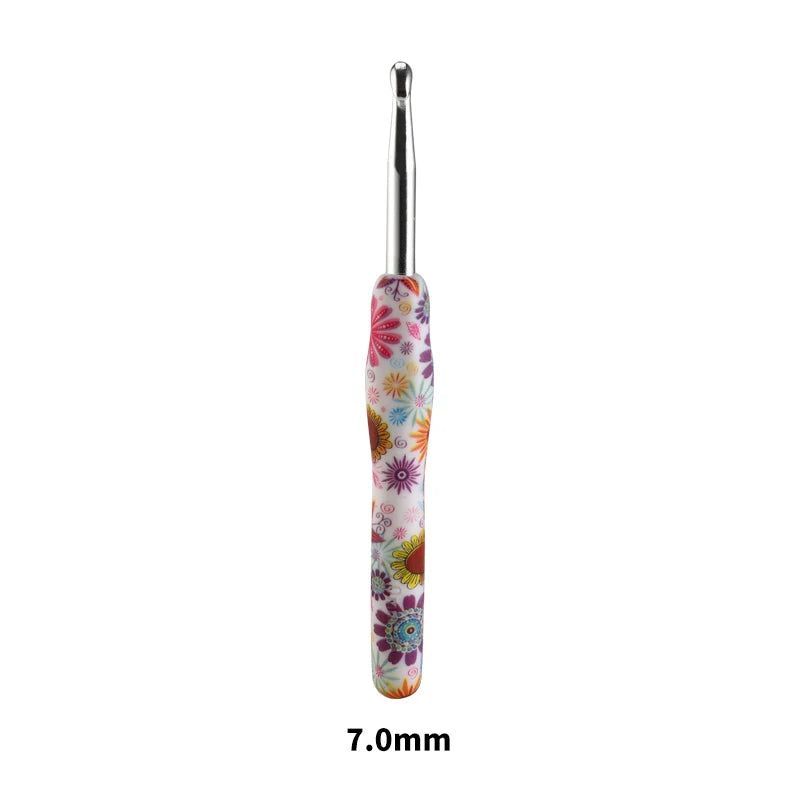 A single handmade crochet knitting hook with a colorful, floral design and a silver tip.