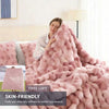 A pink faux fur rabbit blanket draped over a person in a bedroom setting.