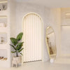 A folding privacy curtain in white is installed in an arched niche on a light-colored wall.