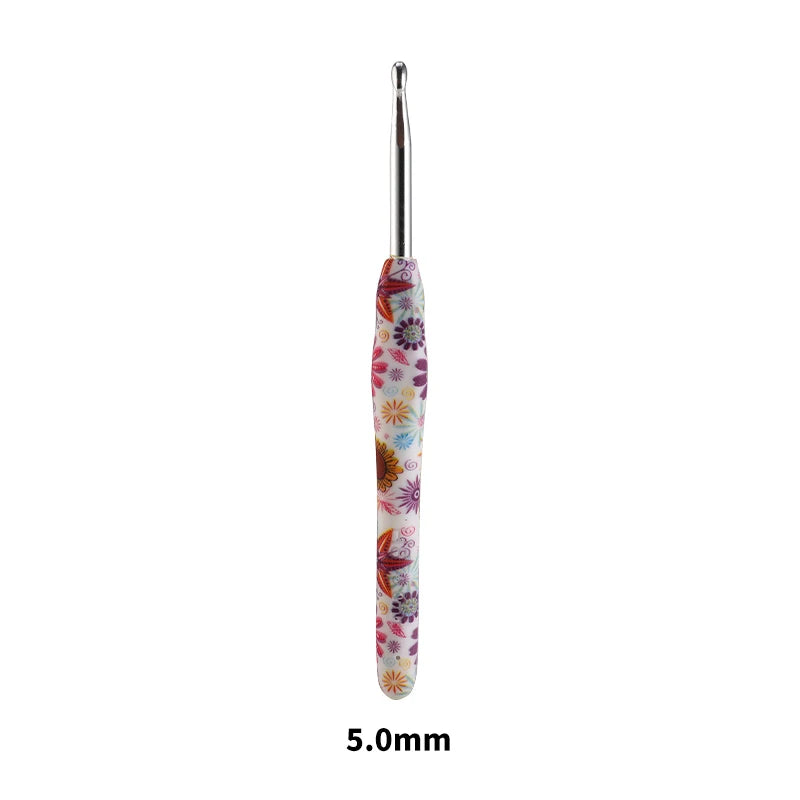 A single handmade crochet knitting hook with a silver shaft and a colorful, patterned handle.