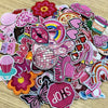A collection of pink and purple embroidered cartoon iron-on patches featuring various shapes and designs.
