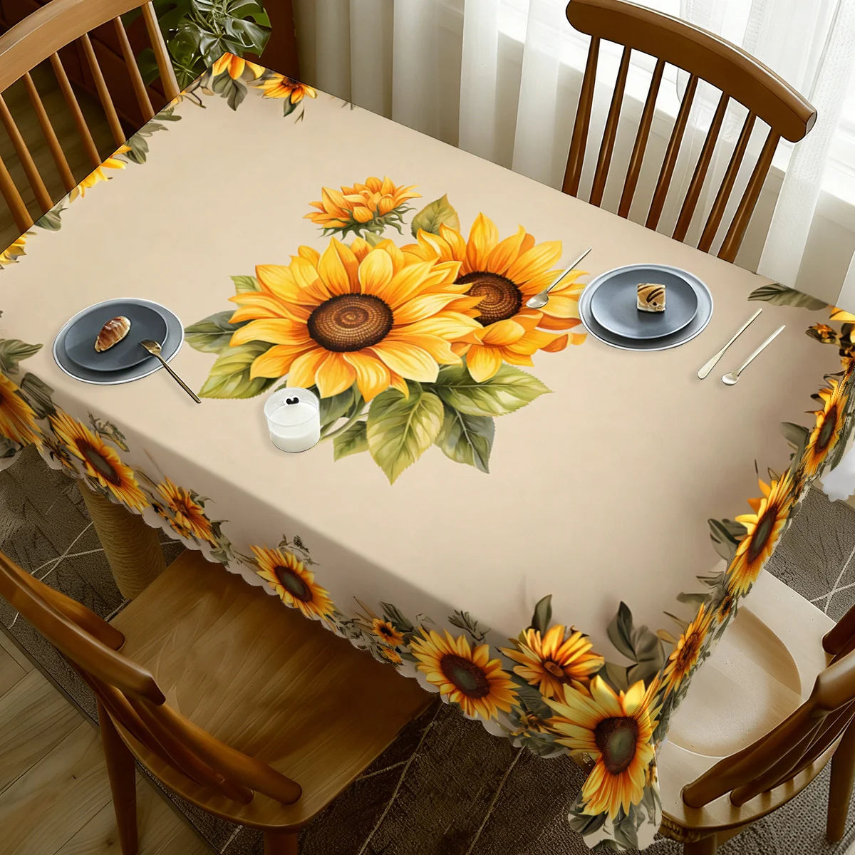 A dining table set with a beige tablecloth featuring a large sunflower floral design and matching plates.