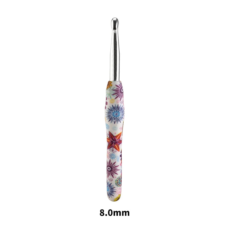 A close-up view of a silver crochet knitting hook with a colorful, floral-patterned handle.