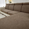 A beige jacquard elastic sofa cushion cover protecting furniture, shown on a sectional sofa in a bright room.