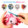 A hand holds a pink crocheted animal toy with floral details, demonstrating the grip of an epoxy crochet hook set.