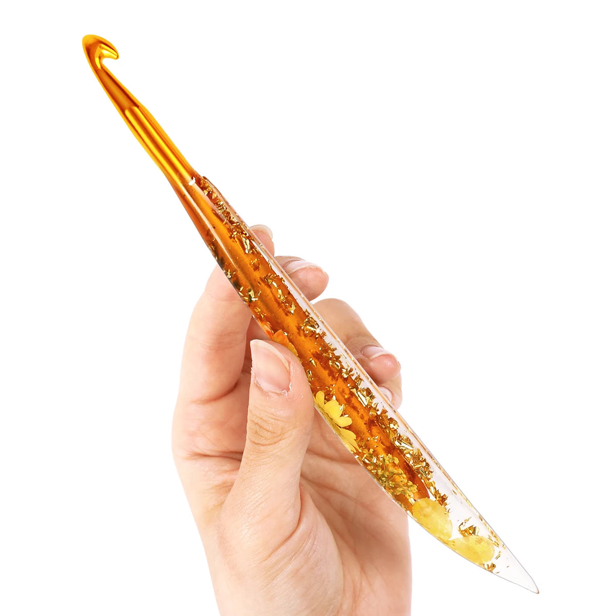A hand holds an orange floral patterned epoxy crochet hook set against a white background.