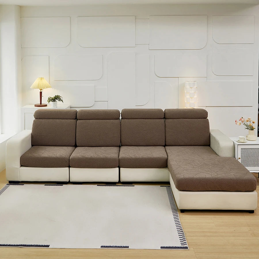 A modern sectional sofa with beige cushions and white trim sits on a light wood floor in a bright room.
