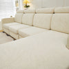 A light beige jacquard elastic sofa cushion cover protecting a sectional sofa in a bright room.