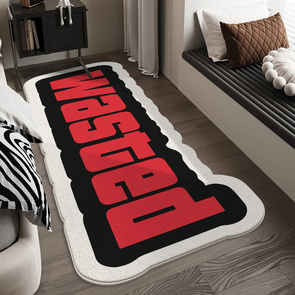 A red and black letter doormat with the word WASTED in a distressed style placed on a wooden floor.
