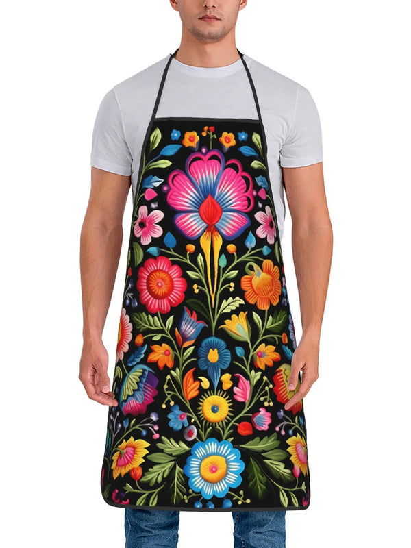 A man models a vintage floral crafting and cooking apron with colorful flowers on a black background.