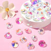 A collection of iridescent crystal glass beads in various colors scattered on a pink surface.