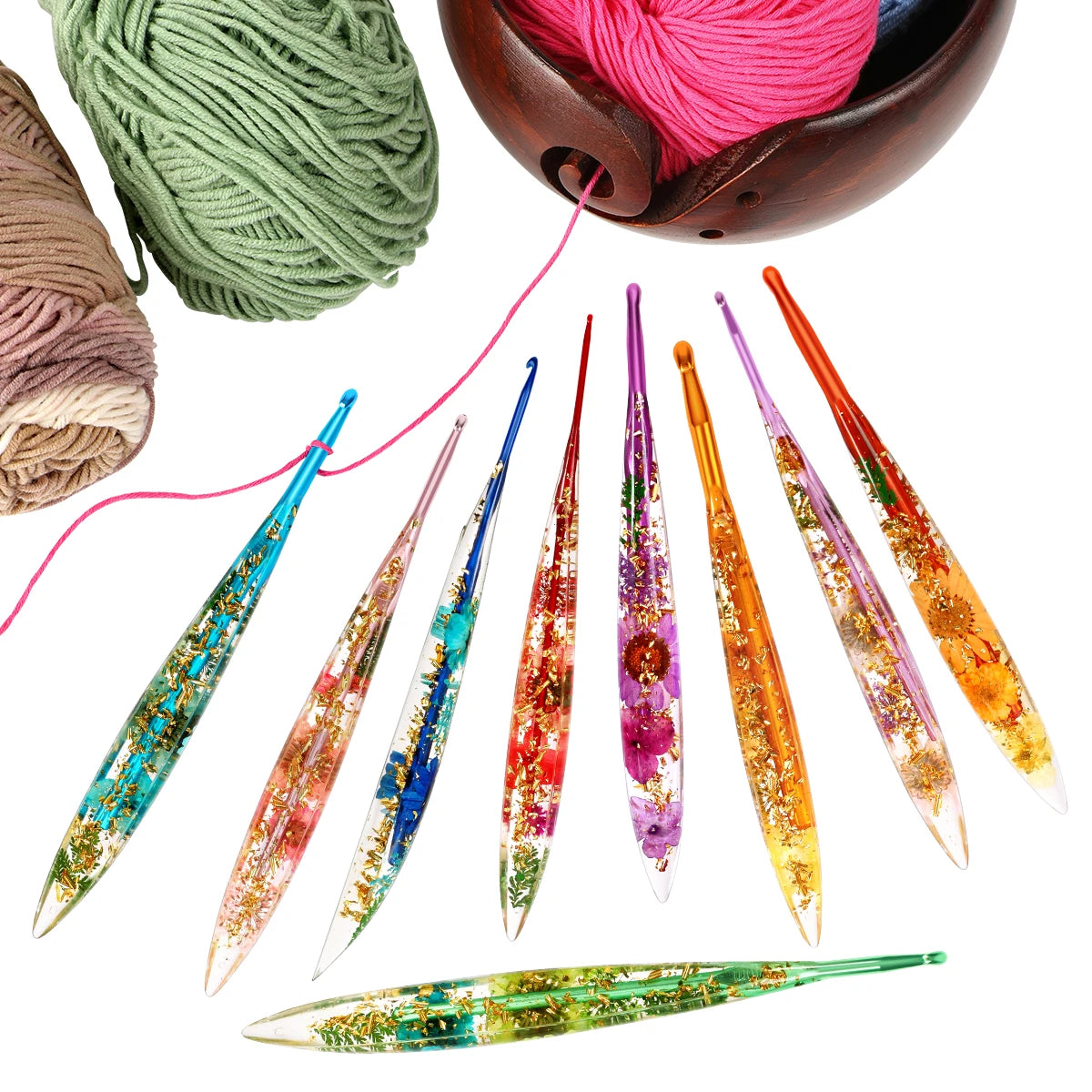 A set of floral patterned epoxy crochet hooks and yarn spools with pink, green, and orange colors.
