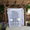 A large white mosquito net is draped over a wooden frame structure outdoors.