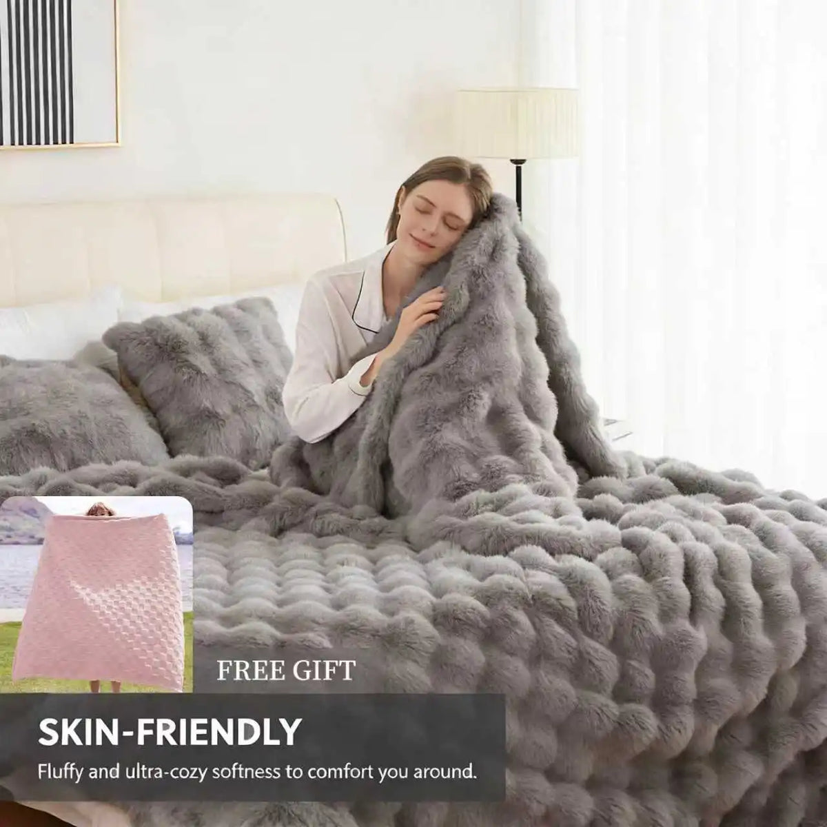 A gray faux fur rabbit blanket draped over a bed, with a pink quilted item nearby.