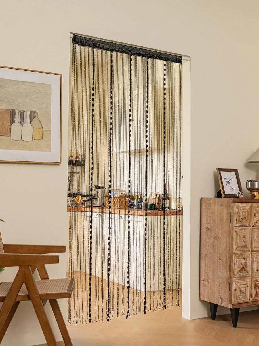 A vertical beaded string curtain covering a doorway, featuring beige and black threads.