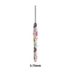 A long, slender crochet knitting hook with a colorful floral design.
