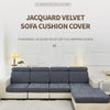 A gray jacquard velvet sofa cushion cover displayed on a white sofa in a bright room.