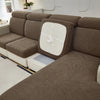 A brown jacquard elastic sofa cushion cover protecting furniture, shown in a close-up view.