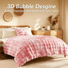 A pink plush faux fur bubble blanket is displayed on a bed, adding texture to the room.