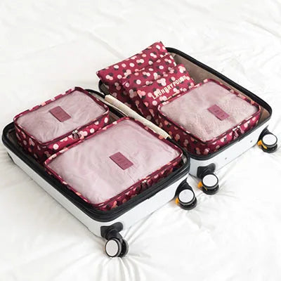 A set of six pink and maroon fabric storage organizers for clothes.