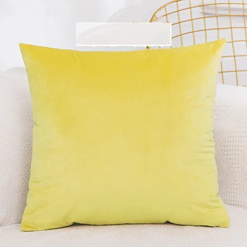 A bright yellow velvet decorative cushion cover resting on a white surface.