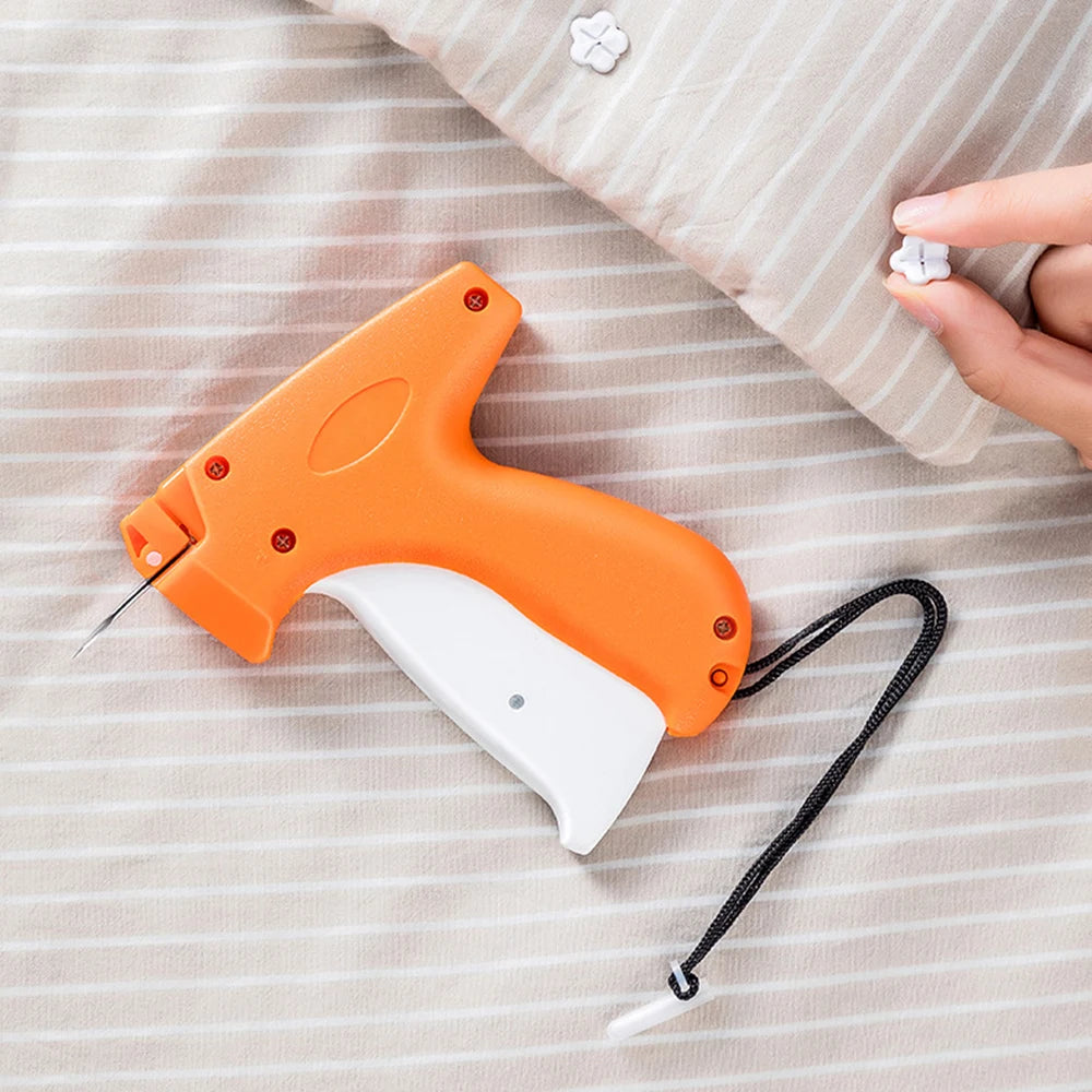An orange and white professional clothing price tagging machine lying on a striped fabric background.