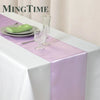 Elegant purple satin table runner displayed on a white tablecloth with silverware and glassware.