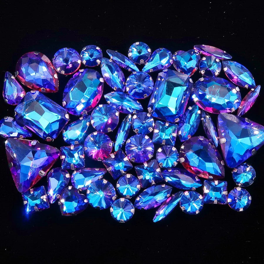A close-up of a set of sparkling blue and purple rhinestones arranged on a dark background.