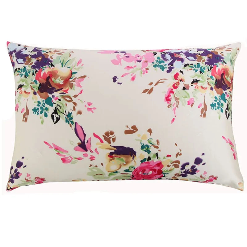 A square silk pillowcase with a floral print featuring pink, purple, and green flowers on a cream background.