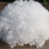 A pile of white, fluffy cotton batting used as a filler for crafting.