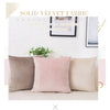A set of three solid velvet decorative cushion covers in shades of beige, pink, and taupe displayed on a white surface.