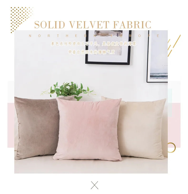 A set of three solid velvet decorative cushion covers in shades of beige, pink, and taupe displayed on a white surface.