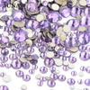 A pile of iridescent purple and silver glass rhinestones for DIY crafts